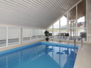 a swimming pool in a house with a table and chairs at 12 person holiday home in Jelsa in Fuglastein