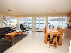 a living room with a table and chairs and a view of the water at 12 person holiday home in Jelsa in Fuglastein