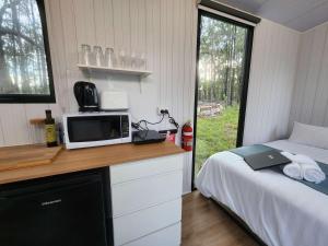 una camera con letto e forno a microonde su un bancone di Solitary Islands Farm 3 by Tiny Away ad Arrawarra