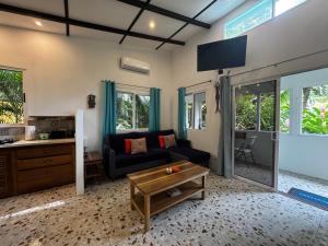 Casita Azul Studio with shared swimming pool في بونتا أوفا: غرفة معيشة بها أريكة وطاولة