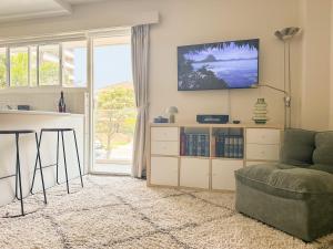 a living room with a couch and a tv on the wall at 150m to Dee Why Beach in Deewhy