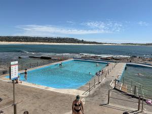 a swimming pool next to the ocean with people in it at 150m to Dee Why Beach in Deewhy