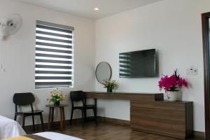 a bedroom with a vanity and a mirror and flowers at Sonne Hotel Quang Binh in Ðộng Hỏi