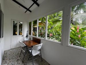 Casita Azul Studio with shared swimming pool في بونتا أوفا: غرفة مع طاولة وكراسي ونوافذ