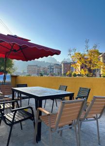 a picnic table with chairs and a red umbrella at Yazhu Creekfront Boutique Hotel in Zhangjiajie