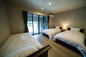 Un dormitorio con dos camas y una gran ventana. en Seaside Villa N - Vacation STAY 21976v, en Mitsugoe