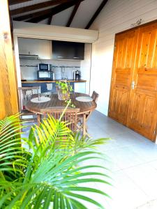 サント・ローズにあるLe Cataleyaの木製テーブルとキッチン付きのパティオ +14枚の写真