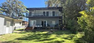 圣殿海岬Greville Getaway - Absolute Waterfront的带阳台和庭院的大房子