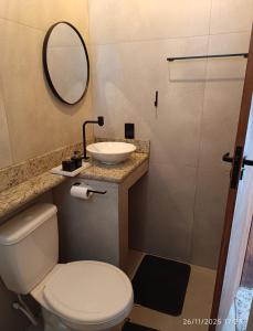 a bathroom with a toilet and a sink and a mirror at Loftshorizontedesalvina in Búzios +36 photos