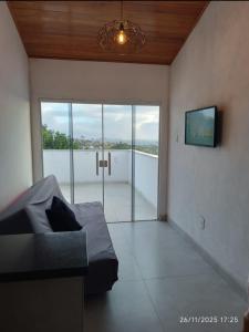 a bedroom with a bed and a tv and a window at Loftshorizontedesalvina in Búzios