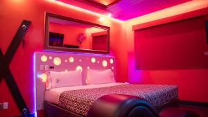 a bedroom with a bed with a mirror and pink lights at Hotel Muy Cdmx, Love Hotel in Mexico City