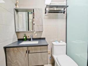 a bathroom with a sink and a toilet and a mirror at A&G Apartment in Zhangjiajie +82 photos