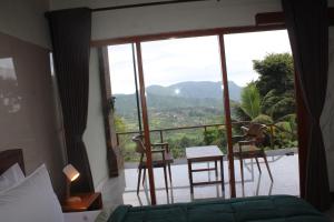 een slaapkamer met een bed en een balkon met uitzicht bij Rumah Bagus Jayanti in Sidemen