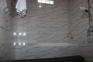 een witte marmeren badkamer met een wastafel en een douche bij Rumah Bagus Jayanti in Sidemen