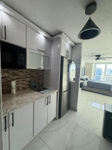 een keuken met witte kasten en een koelkast bij Isla Verde Beach Dreamscape in San Juan +26 foto's
