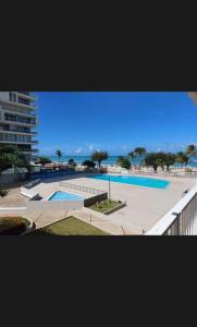 uitzicht op een zwembad met de oceaan op de achtergrond bij Isla Verde Beach Dreamscape in San Juan