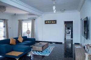 a living room with a blue couch and a table at Nkrabea Royal Apartment in Trofwi