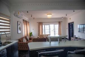 a kitchen and living room with a couch and a table at Nkrabea Royal Apartment in Trofwi