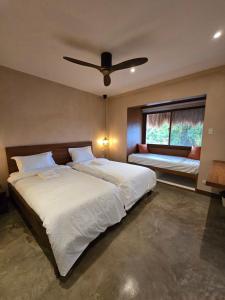 a bedroom with two beds and a ceiling fan at Kāpena Siargao in General Luna +14 photos