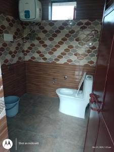 un bagno con un water e una tv a parete di Sanjh Savera Home stay a Dera Gopipur Altre 16 foto