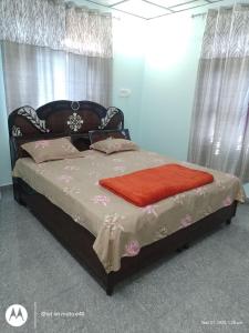 una camera da letto con un letto con una coperta rossa sopra di Sanjh Savera Home stay a Dera Gopipur