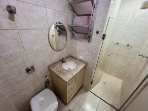 a bathroom with a toilet and a sink and a shower at Apt Praia Mansa Don in Matinhos