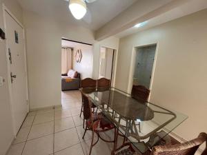 a dining room with a glass table and chairs at Apt Praia Mansa Don in Matinhos