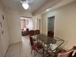 a dining room with a glass table and chairs at Apt Praia Mansa Don in Matinhos