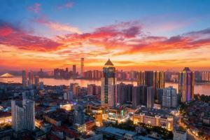 eine Skyline der Stadt in der Abenddämmerung mit einem Sonnenuntergang in der Unterkunft Radisson Blu Hotel Wuhan Jianghan Road Pedestrian Street in Wuhan