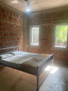 SawantwadiHornbill Soirees Homestay - Aros, North of Goa的一间卧室，床嵌在砖墙里