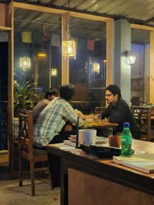 a group of people sitting at a table in a restaurant at Vacation home in Dharmsāla +37 photos