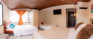 a room with two beds and a window at hotel Dinastia in Tunja +4 photos