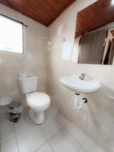 a bathroom with a toilet and a sink at hotel Dinastia in Tunja