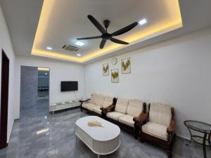 a living room with a couch and a ceiling fan at Vs Homestay Semambu Kuantan in Kuantan