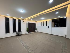a large empty room with white walls and windows at Vs Homestay Semambu Kuantan in Kuantan