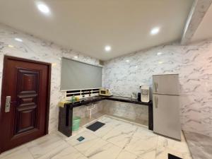 a kitchen with a counter and a refrigerator at Vs Homestay Semambu Kuantan in Kuantan