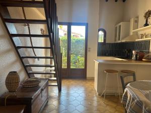 a kitchen with a spiral staircase and a kitchen with a table at Villa T2 Mezzanine, 5 pers, à 600m de la plage. Animaux admis. - FR-1-793-36 in Saint Cyprien Plage