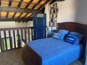 a bedroom with a bed with a blue comforter at Villa T2 Mezzanine, 5 pers, à 600m de la plage. Animaux admis. - FR-1-793-36 in Saint Cyprien Plage
