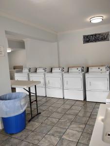 a laundry room with a row of washers and dryers at Gated 2 Double Bed Studio with Full Kitchen 116 in Baton Rouge