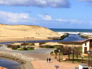 Appartement T3 à Vieux-Boucau, 6 pers, terrasse et parking - FR-1-857-25 في فيو بوكو لي بان: شخصان يسيران على شاطئ بجوار المحيط +3 صور