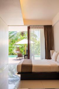 ヌサドゥアにあるザ ワングサ ベノアのベッドと大きな窓のある寝室