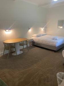Camera con letto, tavolo, letto e scrivania. di Billabong Wangaratta a Wangaratta