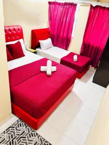 Kampong Bukit BungaBUKIT BUNGA Inn的配有粉红色窗帘的客房内的两张床