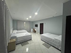 Una habitación de hotel con dos camas y un televisor. en Ev Home, en Cruzeiro do Sul 24 fotos más