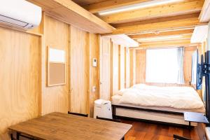 a small bedroom with a bed and a table at MOBILITA COURT IWATE in Hachimantai