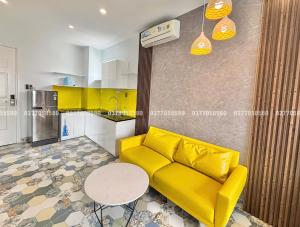 uma sala de estar com um sofá amarelo e uma mesa em Sea House Hotels and Apartments em Vung Tau