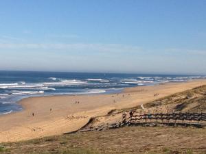 莫列马阿Villa pour 6 pers à Moliets avec animaux admis - FR-1-857-28的沙滩上的人在沙滩上和大海上散步 更多3张照片