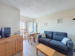布科·莱斯白老城Appartement T2 avec piscine, parking - Vieux-Boucau - FR-1-857-41的客厅里有一张蓝色的沙发和一张桌子
