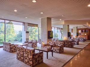 三朝町にある三朝ロイヤルホテルの椅子とテーブル、大きな窓のあるロビー