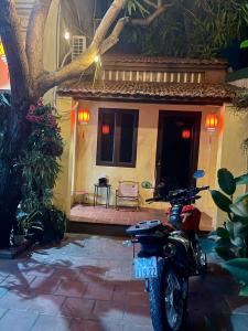 una motocicleta estacionada frente a una casa en Lee Homestay, en Hanói
